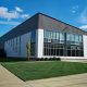 Modern industrial building with large windows and clear sky.